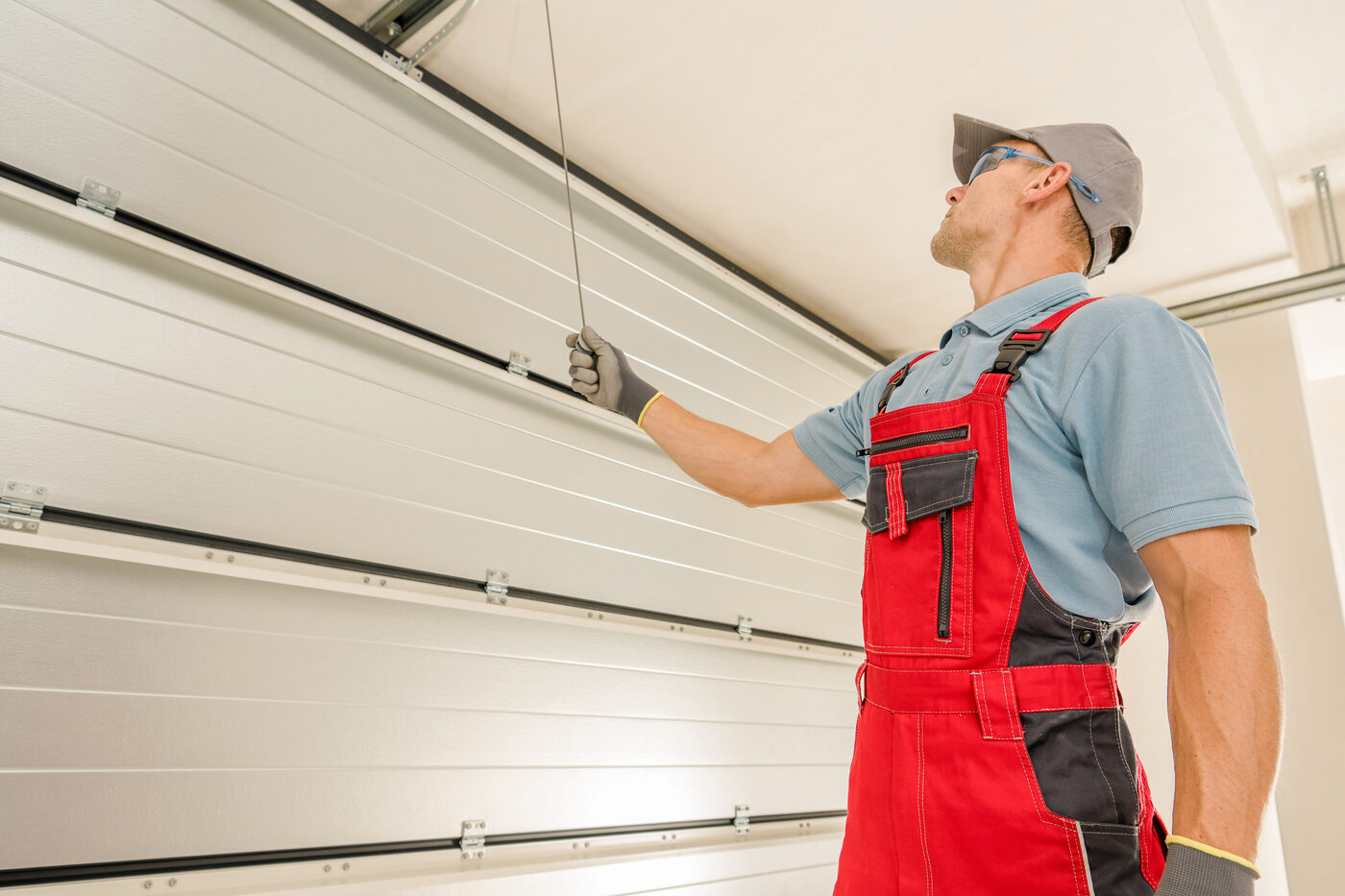 Garage door technician servicing an overhead door